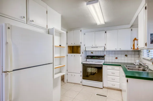 a kitchen with a stove top oven and refrigerator