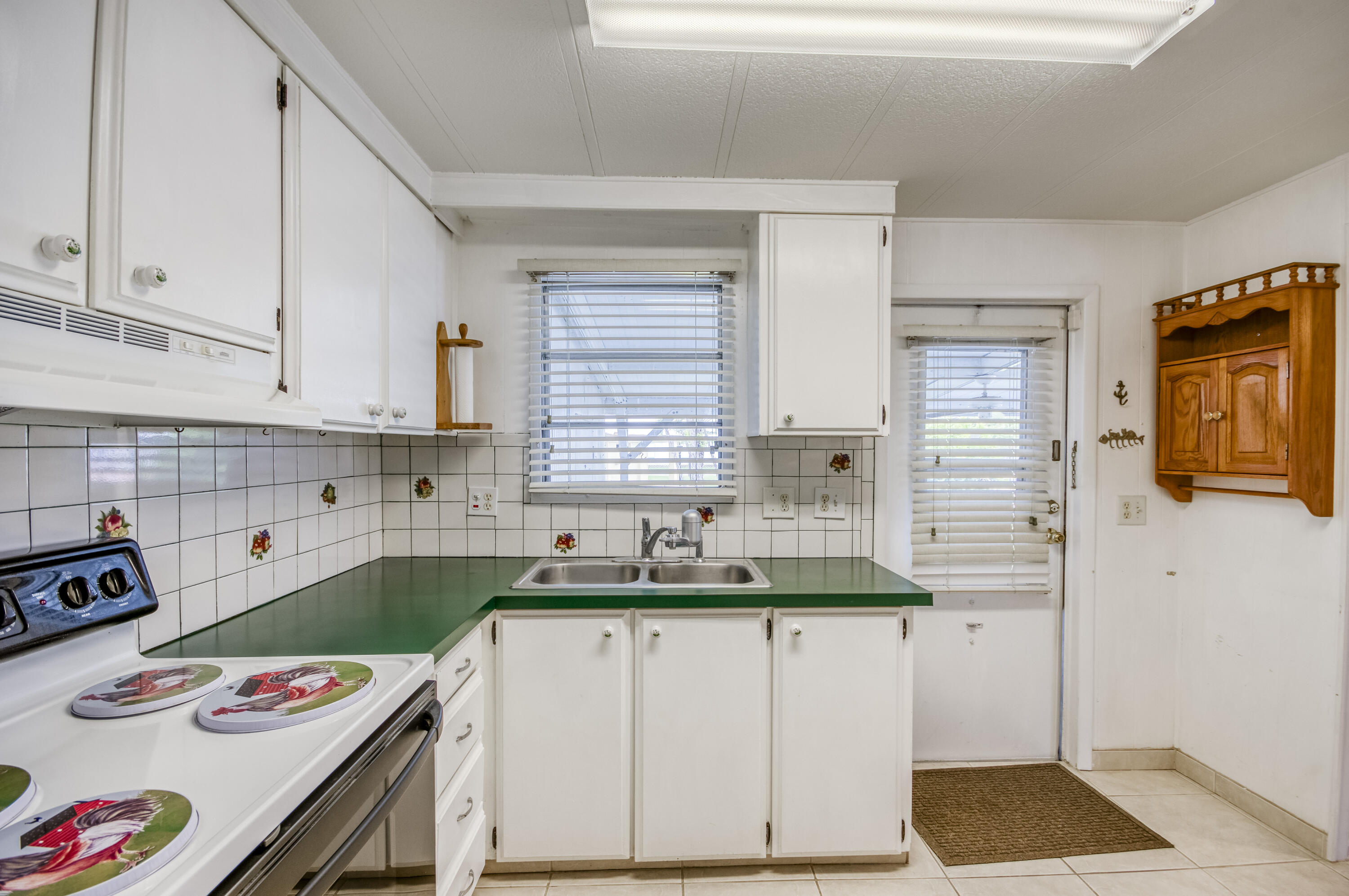 4800 Southeast Federal Highway, Unit 17 Stuart, FL 34997 - Photo 10 of 29 a kitchen with a sink a stove and white cabinets