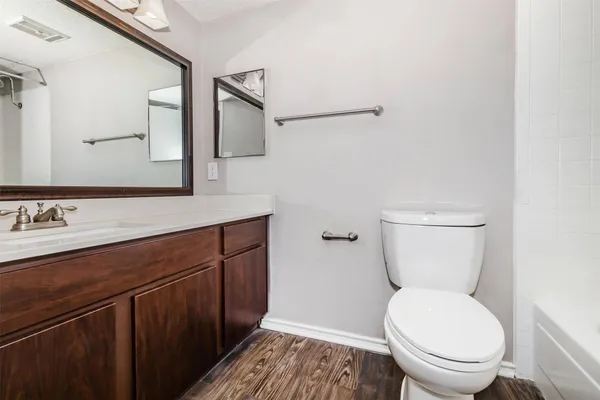 a bathroom with a toilet a sink and mirror