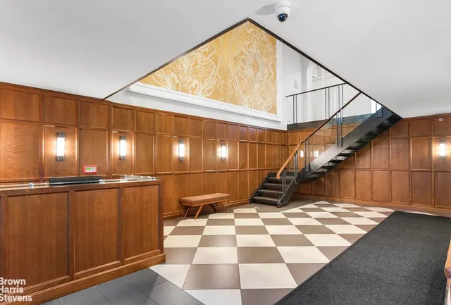 a view of a hallway with wooden floor and black white checkered floor