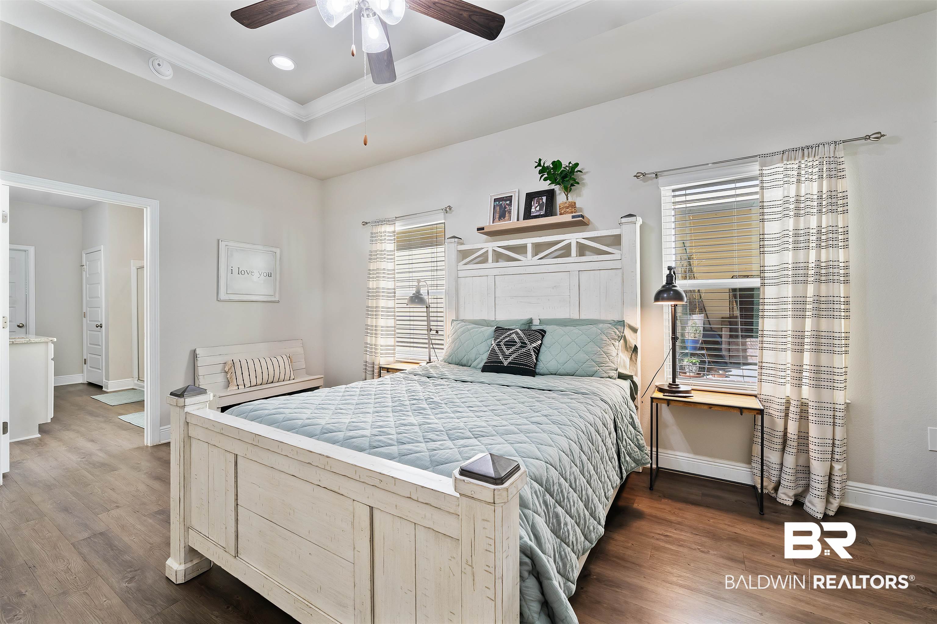 1221 Primrose Lane Foley, AL 36535 - Photo 11 of 29 Bedroom featuring a ceiling fan, baseboards, dark wood finished floors, a tray ceiling, and crown molding