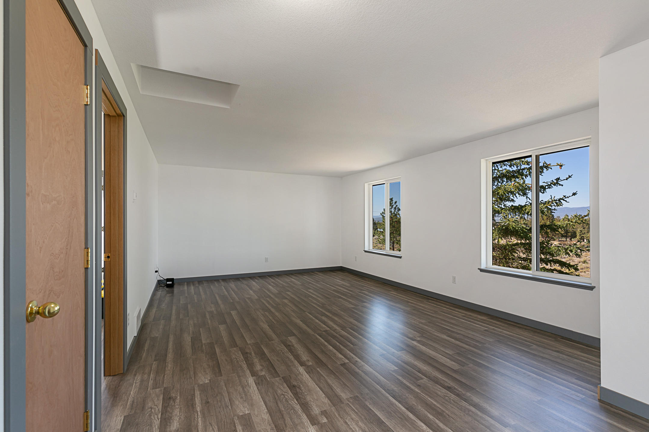 65158 Hunnell Road Bend, OR 97703 - Photo 12 of 31 a view of an empty room with wooden floor and a window