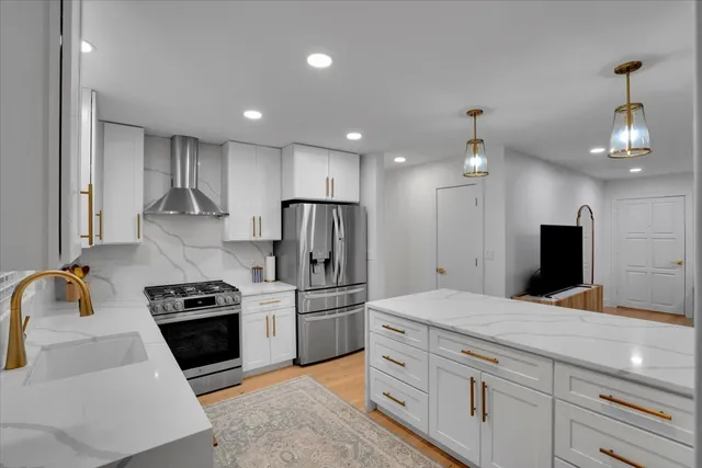 a kitchen with kitchen island granite countertop stainless steel appliances cabinets a sink and a counter top space