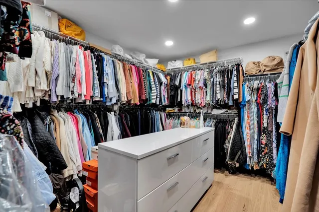 a view of walk in closet with clothes