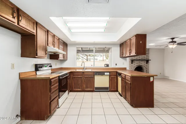a kitchen with stainless steel appliances granite countertop a stove top oven a sink a counter top space and cabinets