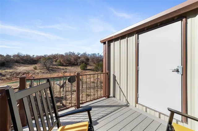 a view of balcony with wooden floor & fence