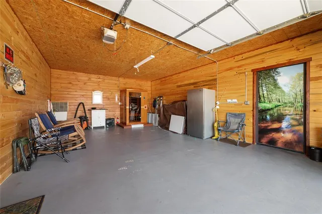 a view of a patio with table and chairs and barbeque grill with floor to ceiling window