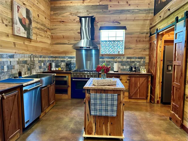 a kitchen with stainless steel appliances kitchen island granite countertop a stove a sink dishwasher and cabinets