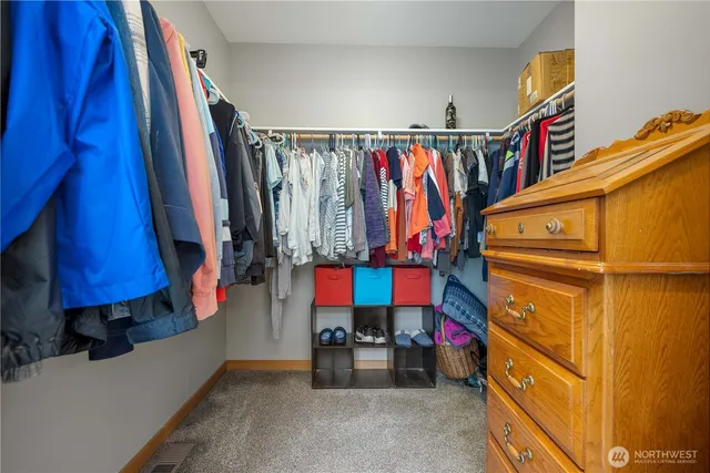 a view of walk in closet with clothes and shoes