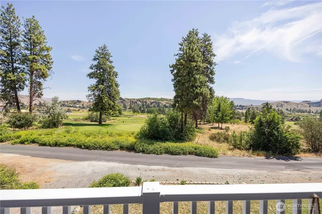 a view of a yard with flower plants and wooden fence