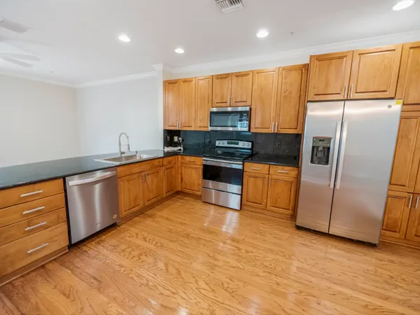a kitchen with stainless steel appliances granite countertop a refrigerator a stove a sink and a microwave