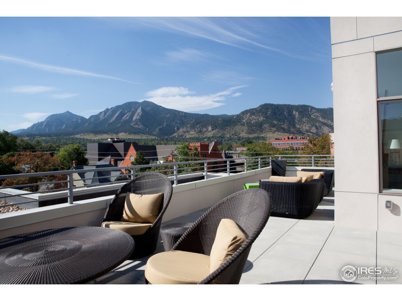 a view of a patio with couches chairs under an umbrella