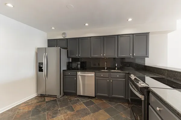 a kitchen with a sink a refrigerator and cabinets