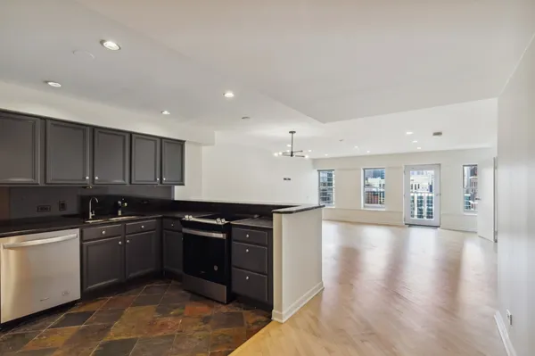 a kitchen with stainless steel appliances granite countertop a sink stove and cabinets