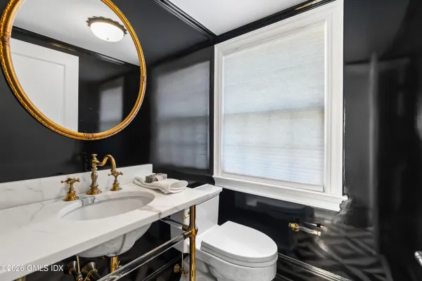a bathroom with a toilet a sink and mirror