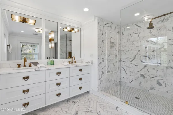 a bathroom with a double vanity sink toilet a shower and a mirror