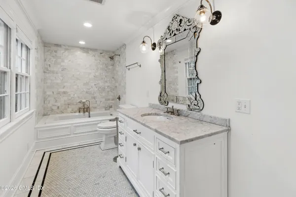 a bathroom with a granite countertop sink mirror and a bathtub