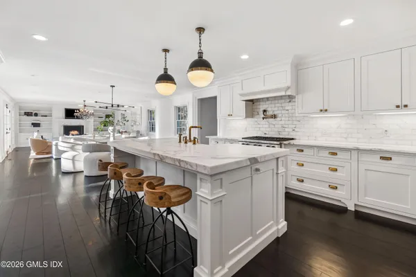a kitchen with white cabinets stainless steel appliances and wooden floor