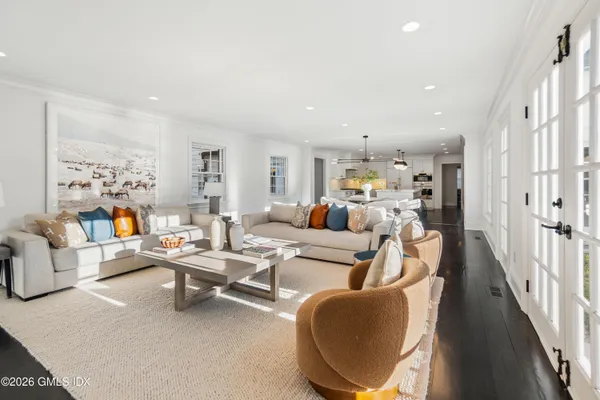 a living room with furniture kitchen view and a large window