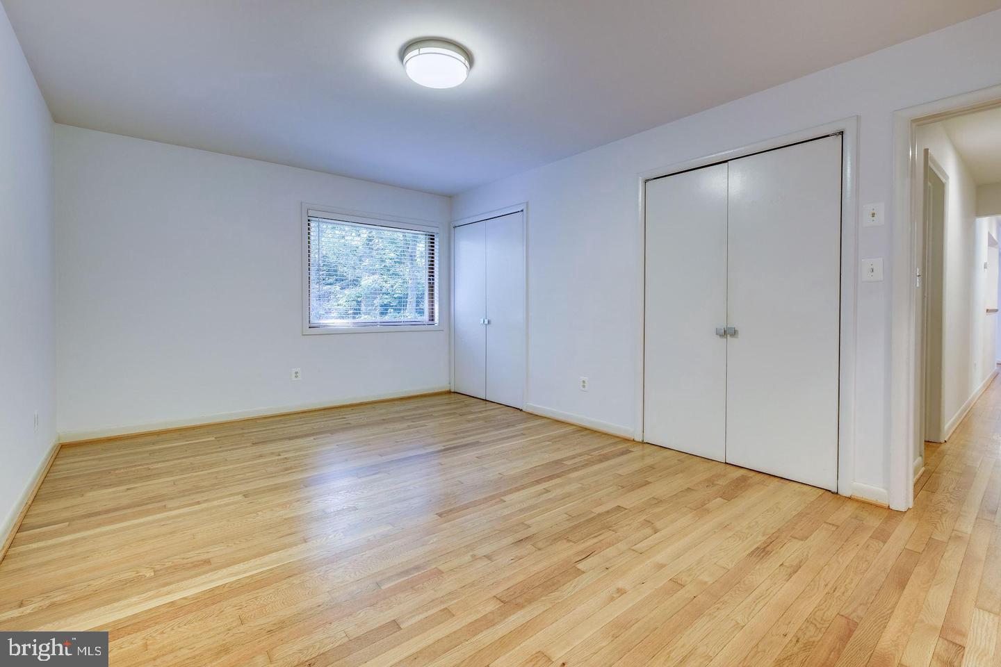 6710 Persimmon Tree Road Bethesda, MD 20817 - Photo 12 of 39 an empty room with wooden floor and window