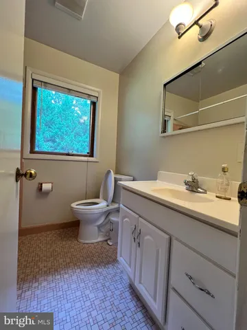 a spacious bathroom with a toilet sink and mirror