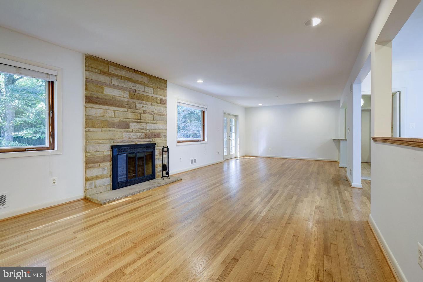 6710 Persimmon Tree Road Bethesda, MD 20817 - Photo 4 of 39 a view of empty room with wooden floor and fireplace