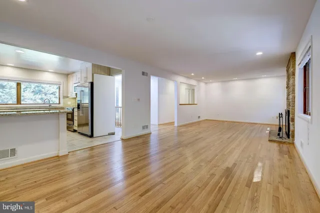 a view of a big room with wooden floor and a kitchen