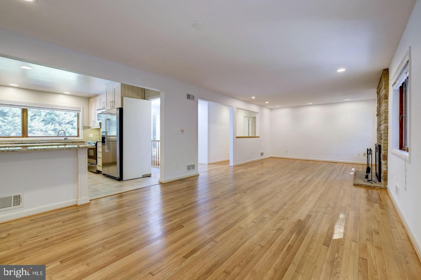 6710 Persimmon Tree Road Bethesda, MD 20817 - Photo 5 of 39 a view of a big room with wooden floor and a kitchen