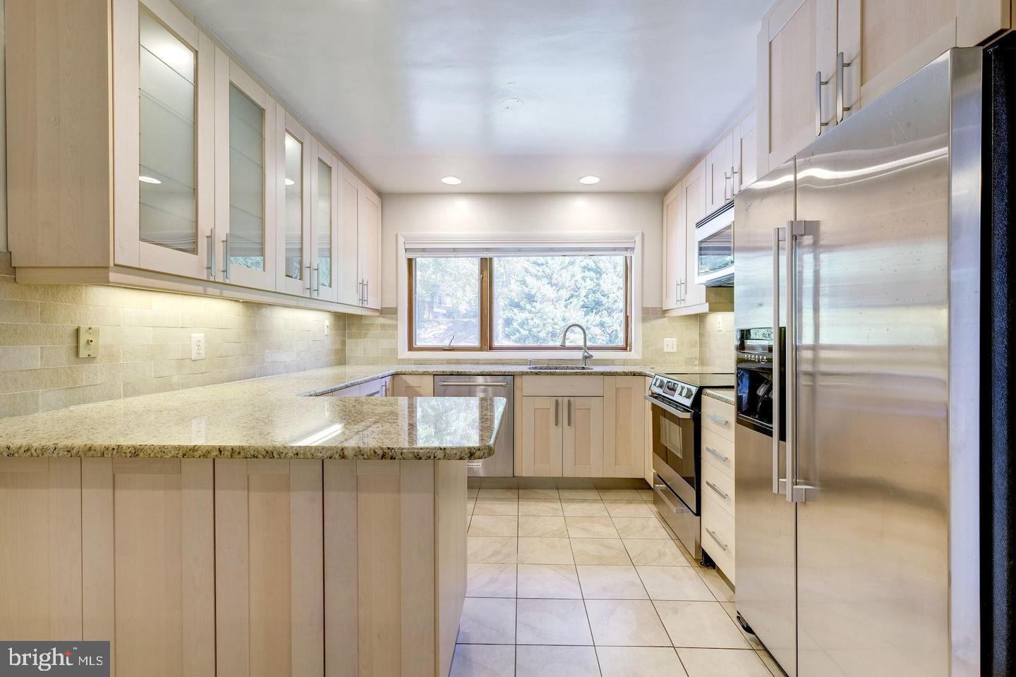 6710 Persimmon Tree Road Bethesda, MD 20817 - Photo 6 of 39 a kitchen with a refrigerator a sink and cabinets