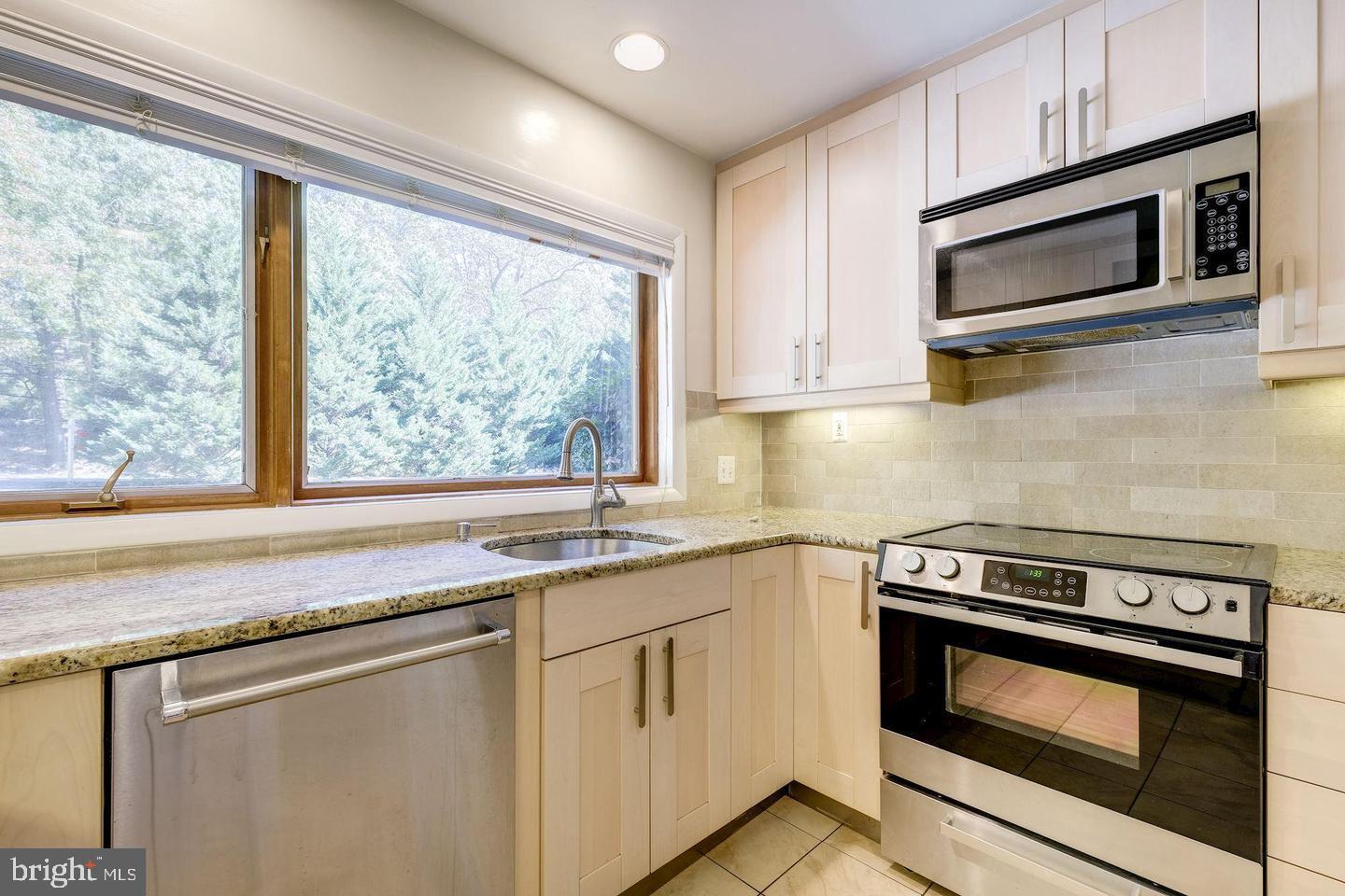 6710 Persimmon Tree Road Bethesda, MD 20817 - Photo 7 of 39 a kitchen with granite countertop a stove microwave and sink