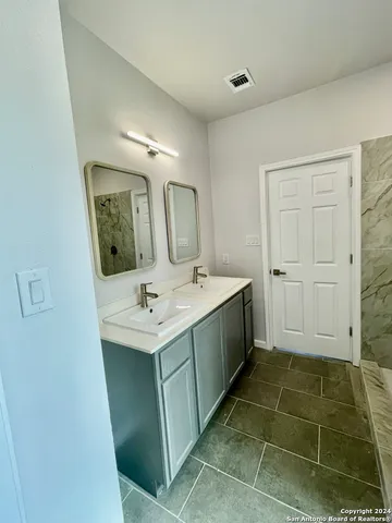 a bathroom with a sink vanity and tub
