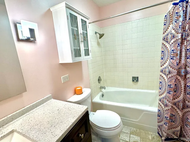 a bathroom with a sink a toilet a shower curtain and a bath tub