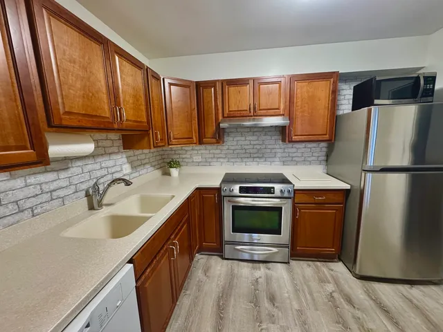a kitchen with stainless steel appliances granite countertop a refrigerator sink and stove