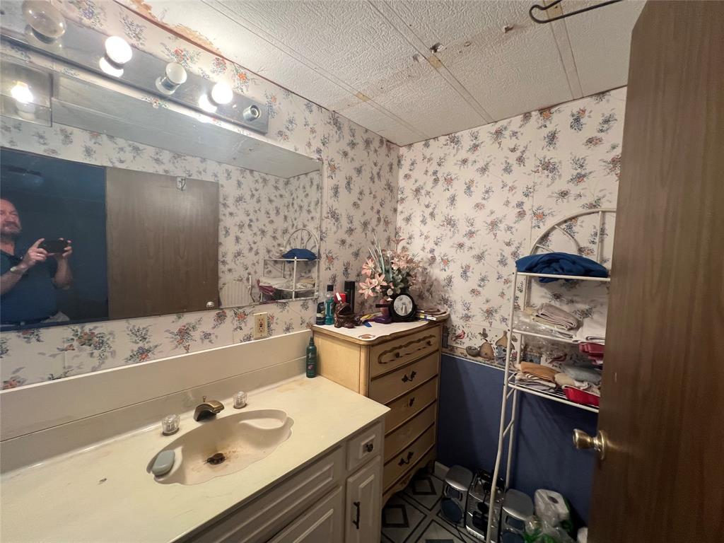 0 Holland Road Forestburg, TX 76239 - Photo 27 of 39 a bathroom with a sink vanity granite and a mirror