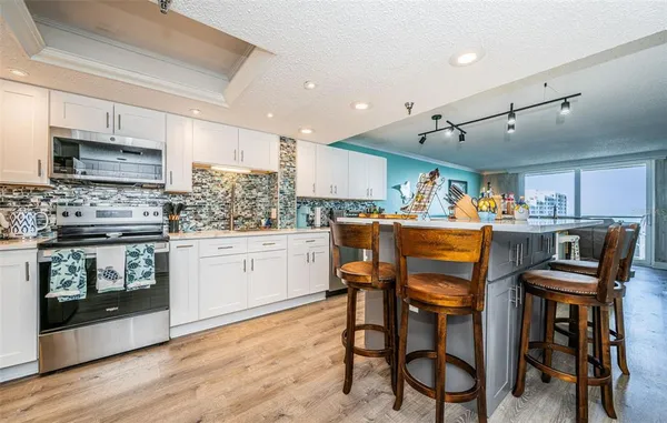 a kitchen with a table chairs microwave and cabinets