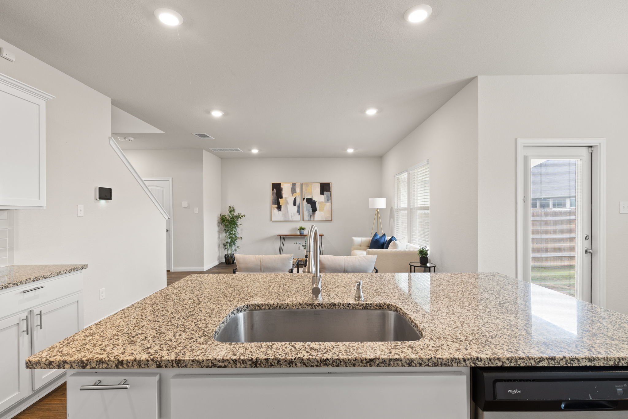 281 Jayden Drive Kyle, TX 78640 - Photo 15 of 36 Kitchen island with granite countertops, an undermount stainless steel sink, and a modern faucet