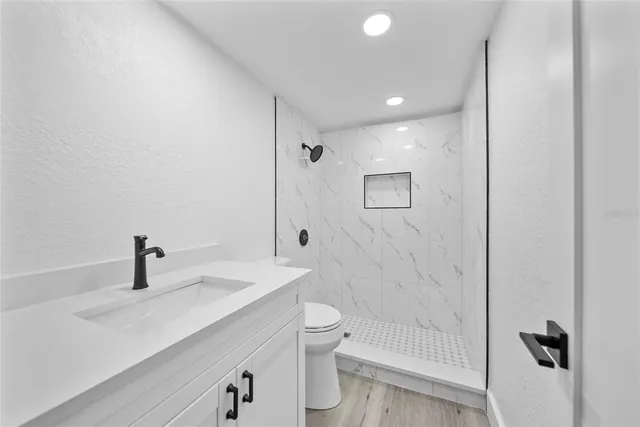 a bathroom with a sink a toilet and shower