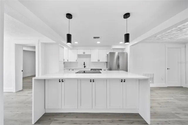 a kitchen with white cabinets and sink