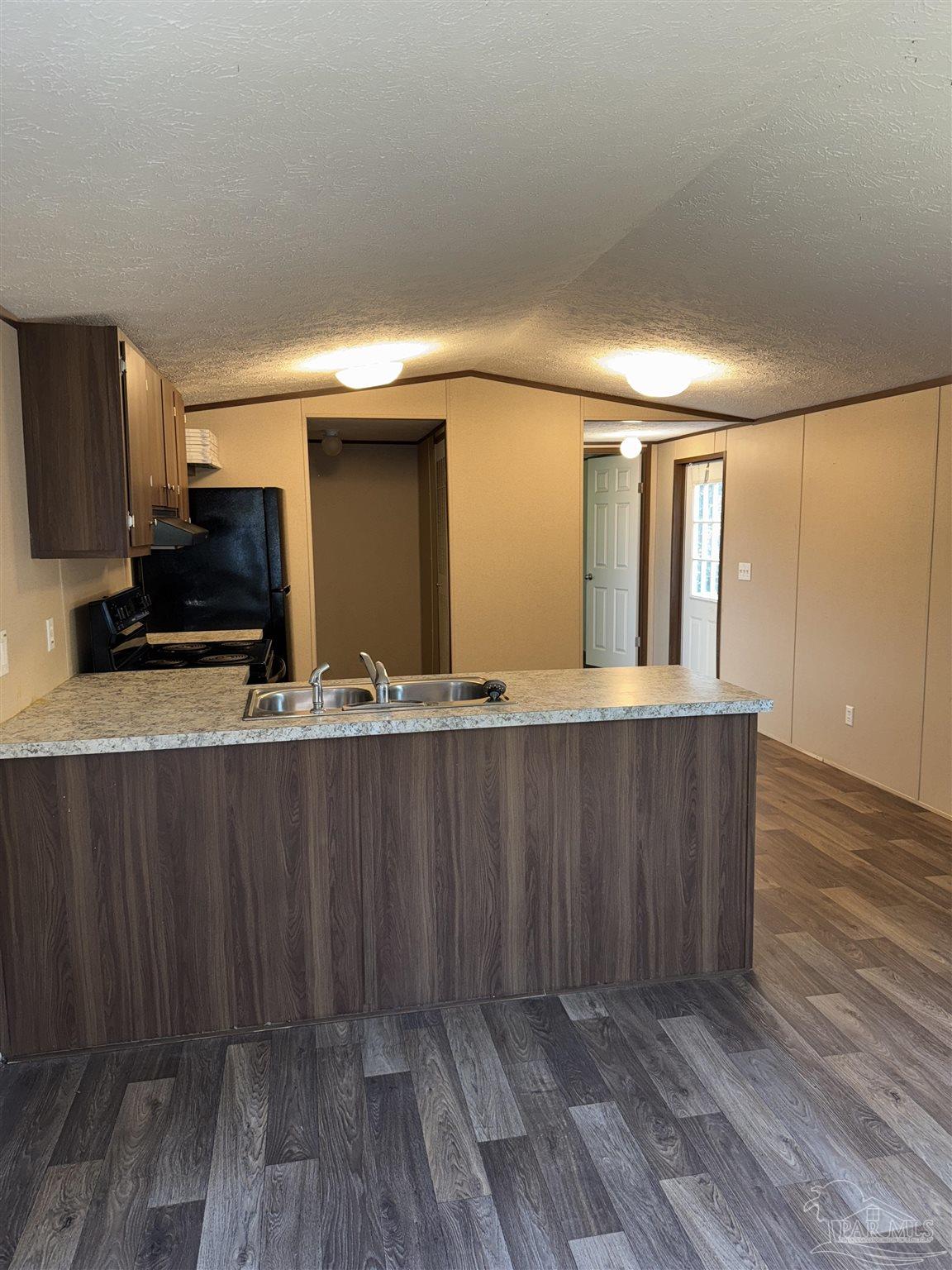 5049 Bent Tree Road Milton, FL 32583 - Photo 11 of 34 a view of a kitchen with wooden floor and cabinets