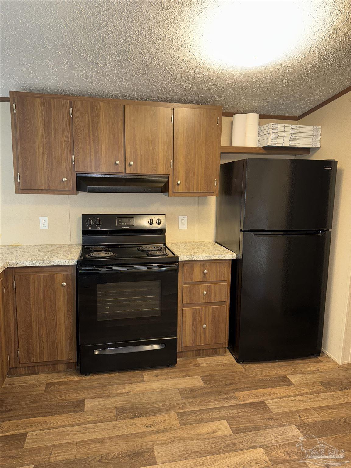 5049 Bent Tree Road Milton, FL 32583 - Photo 12 of 34 a kitchen with a refrigerator stove and cabinets