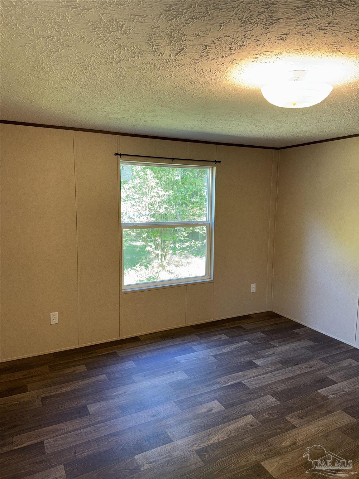 5049 Bent Tree Road Milton, FL 32583 - Photo 19 of 34 an empty room with wooden floor and windows