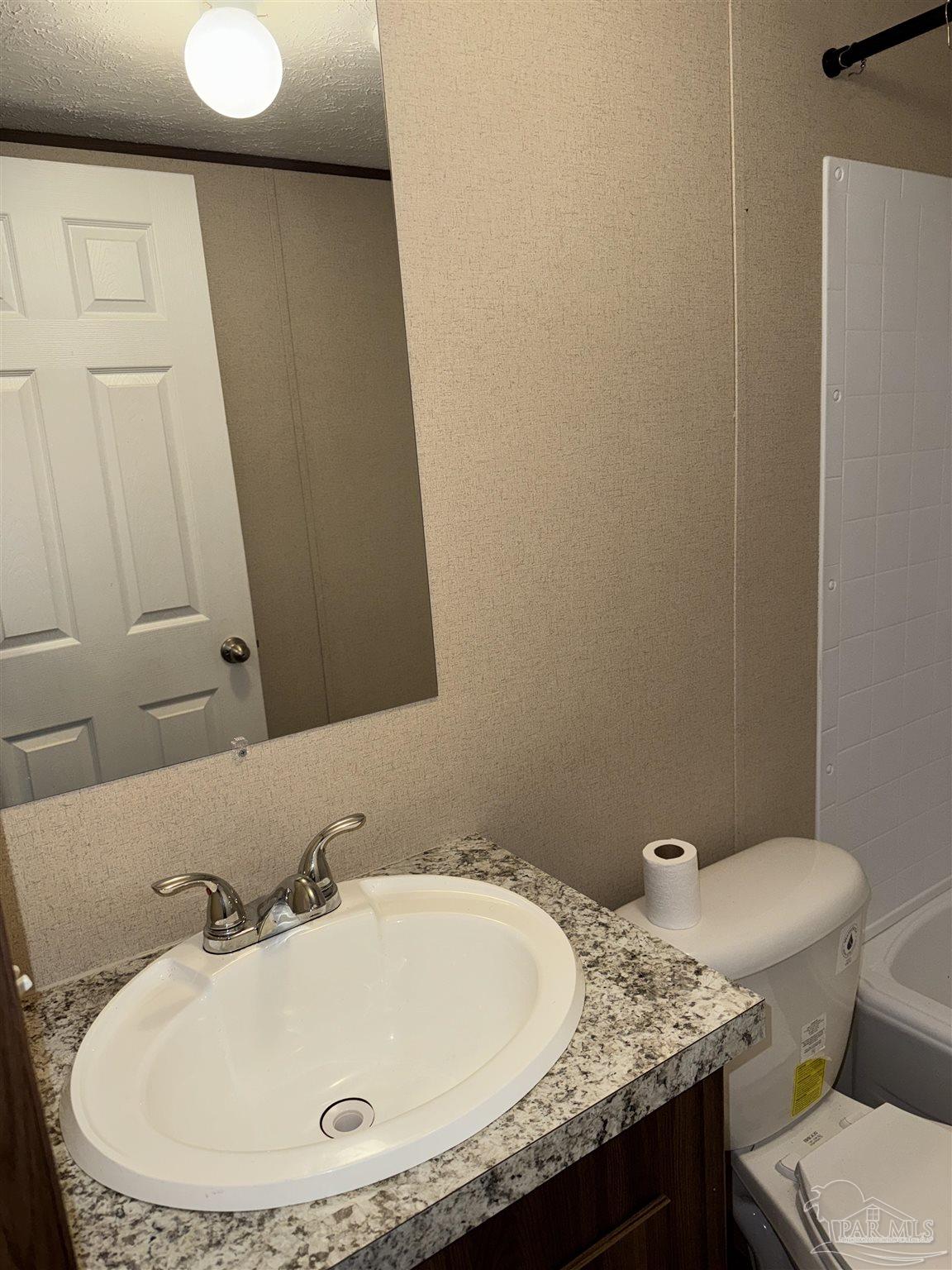 5049 Bent Tree Road Milton, FL 32583 - Photo 33 of 34 a bathroom with a granite countertop sink and a mirror