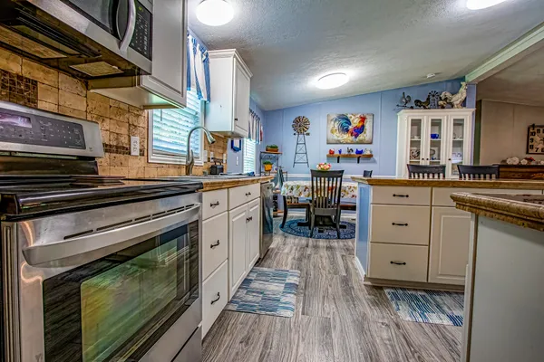a kitchen with stainless steel appliances a stove and cabinets