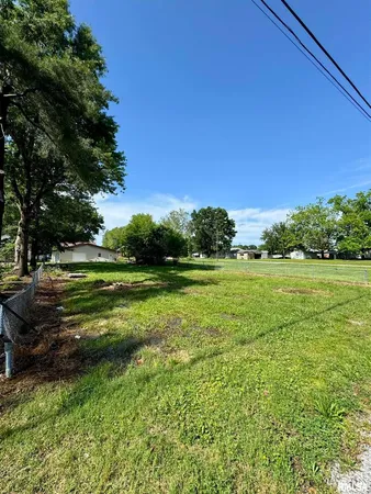 a view of a grassy field with trees