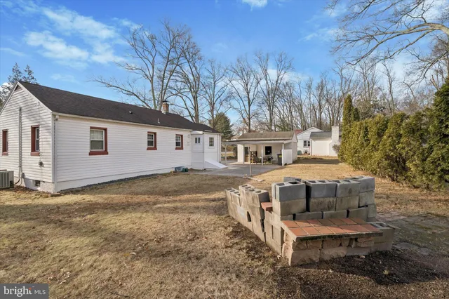 a view of a white house with a big yard and large tree