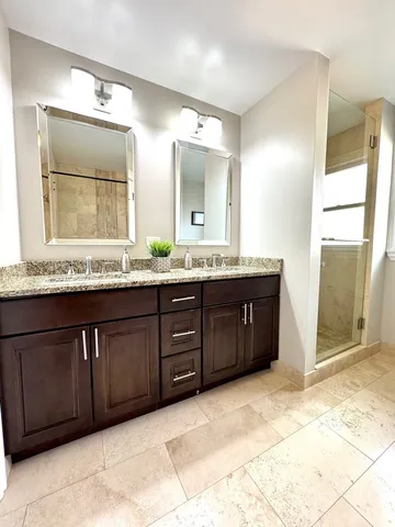 a bathroom with a granite countertop sink and a mirror
