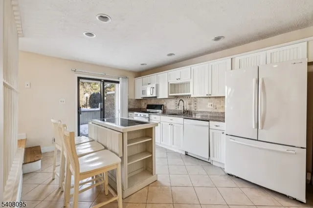 a kitchen with white cabinets and white appliances