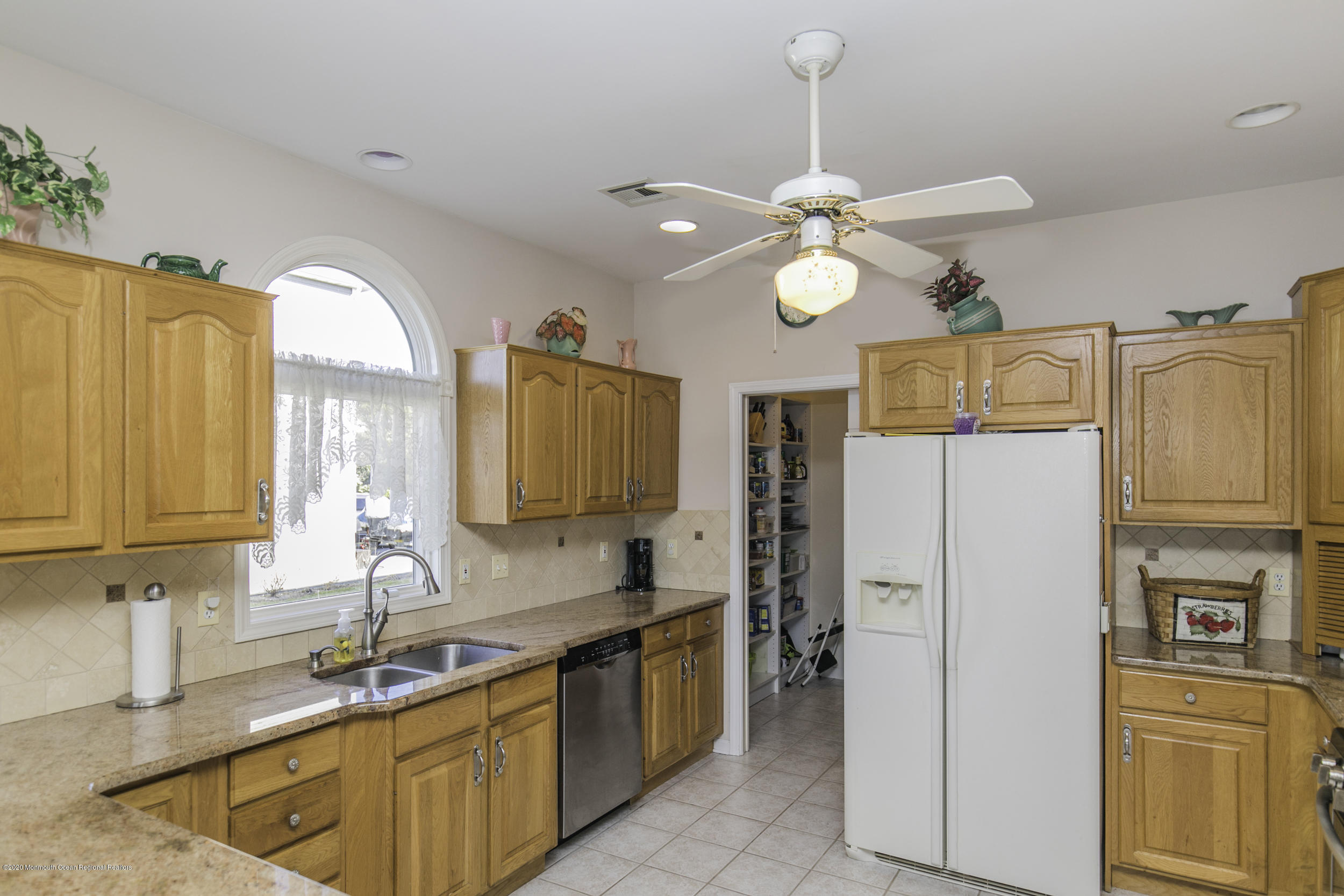60 Seagoin Road Brick, NJ 08723 - Photo 24 of 53 a kitchen with stainless steel appliances granite countertop a refrigerator a sink dishwasher a stove a dining table and chairs with wooden floor