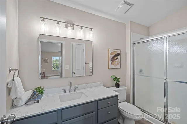 a bathroom with a granite countertop sink a toilet and a mirror