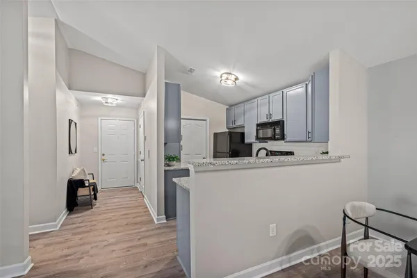 a kitchen with stainless steel appliances granite countertop a refrigerator and a stove top oven